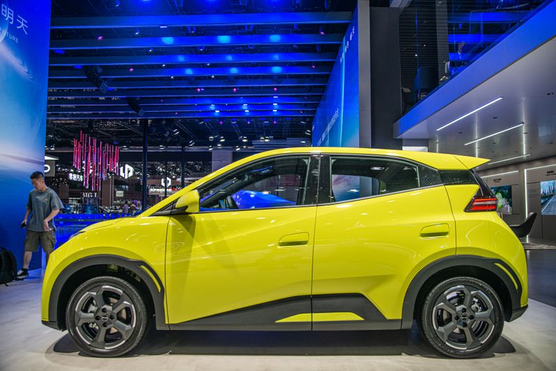 A compact yellow four-door car in a showroom.