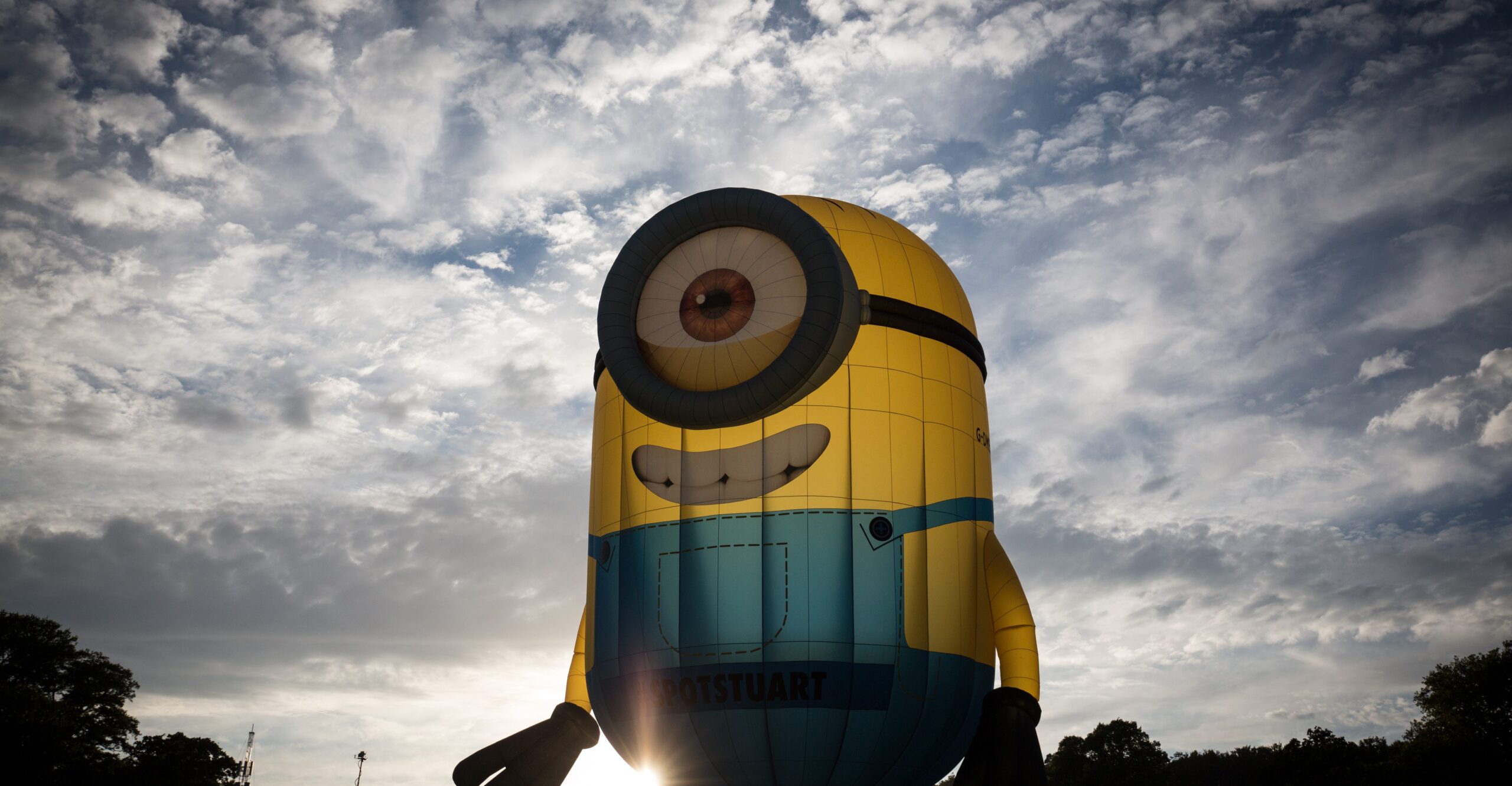 A balloon in the image of a minion, against a dramatic sky.