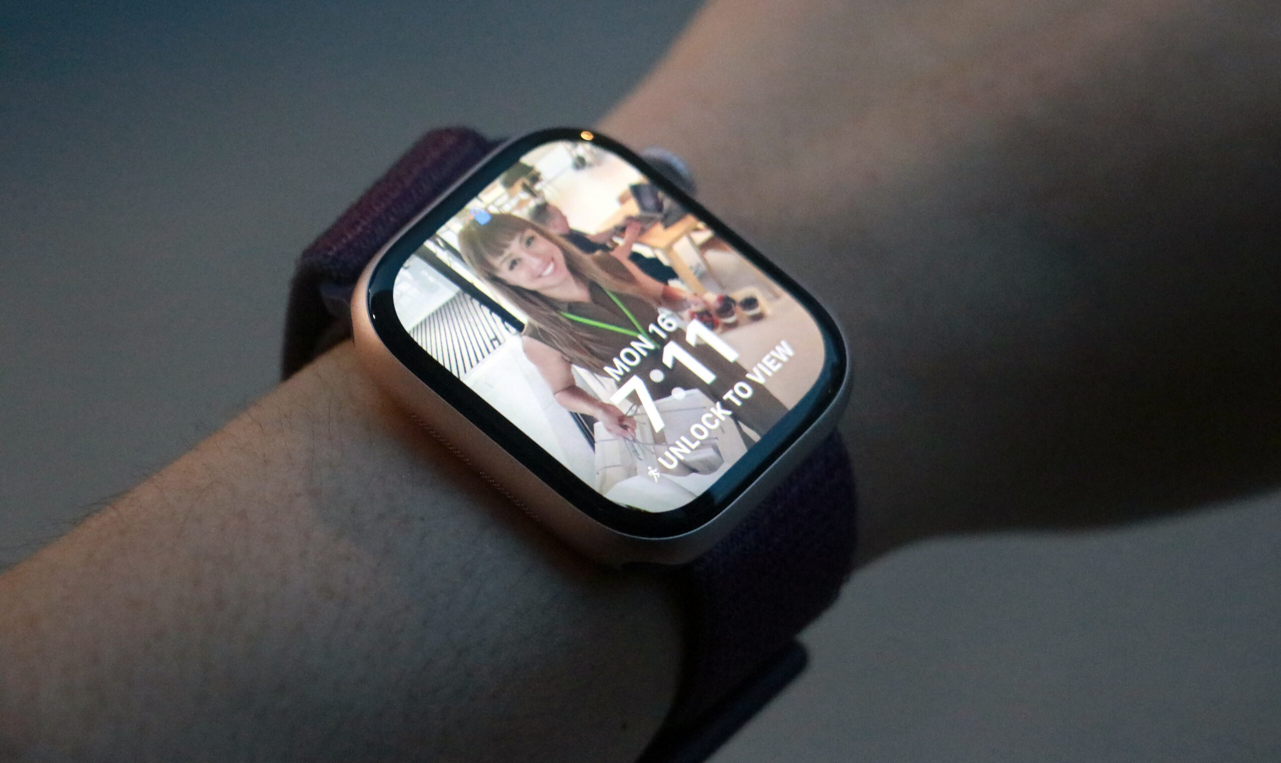 The Apple Watch Series 10 with a Photos watch face open on its home screen, worn on a wrist held in mid-air.