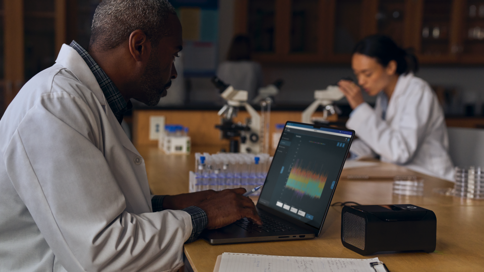 A person sitting in a lab, using the new MacBook Pro with M4 chip.