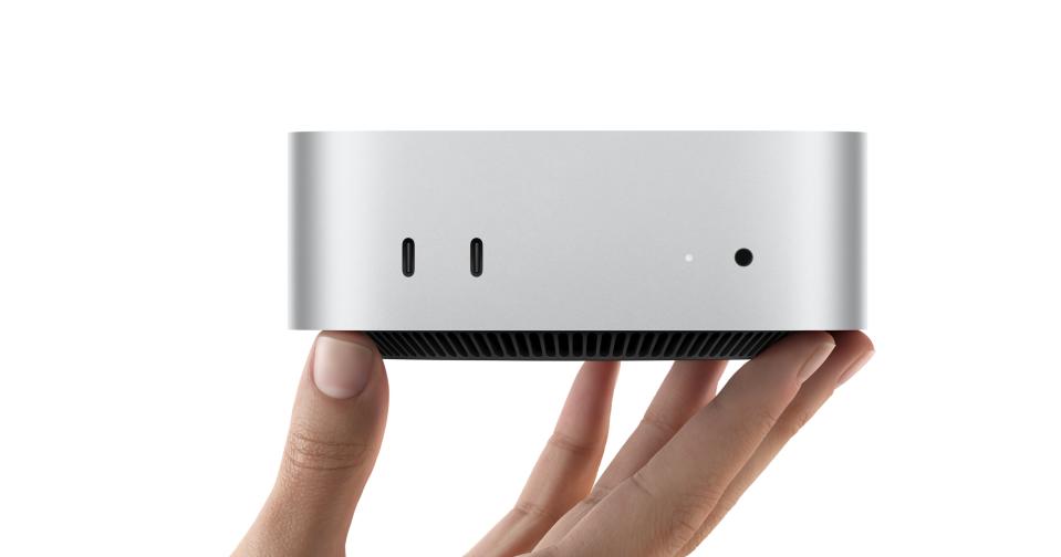 Closeup of a person's hand holding the new (tiny) Mac mini