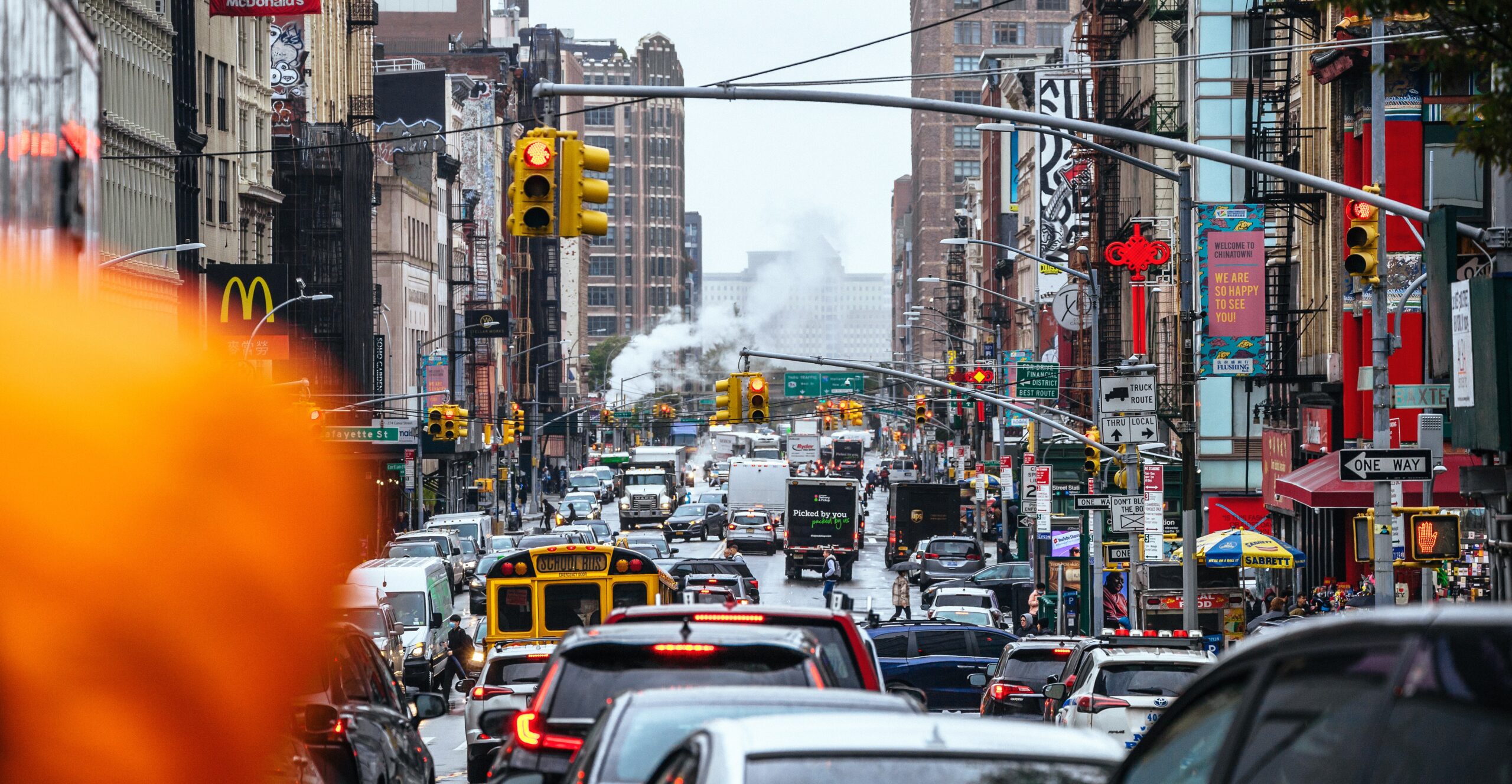 Cars, trucks, and buses crowded on a busy city street.