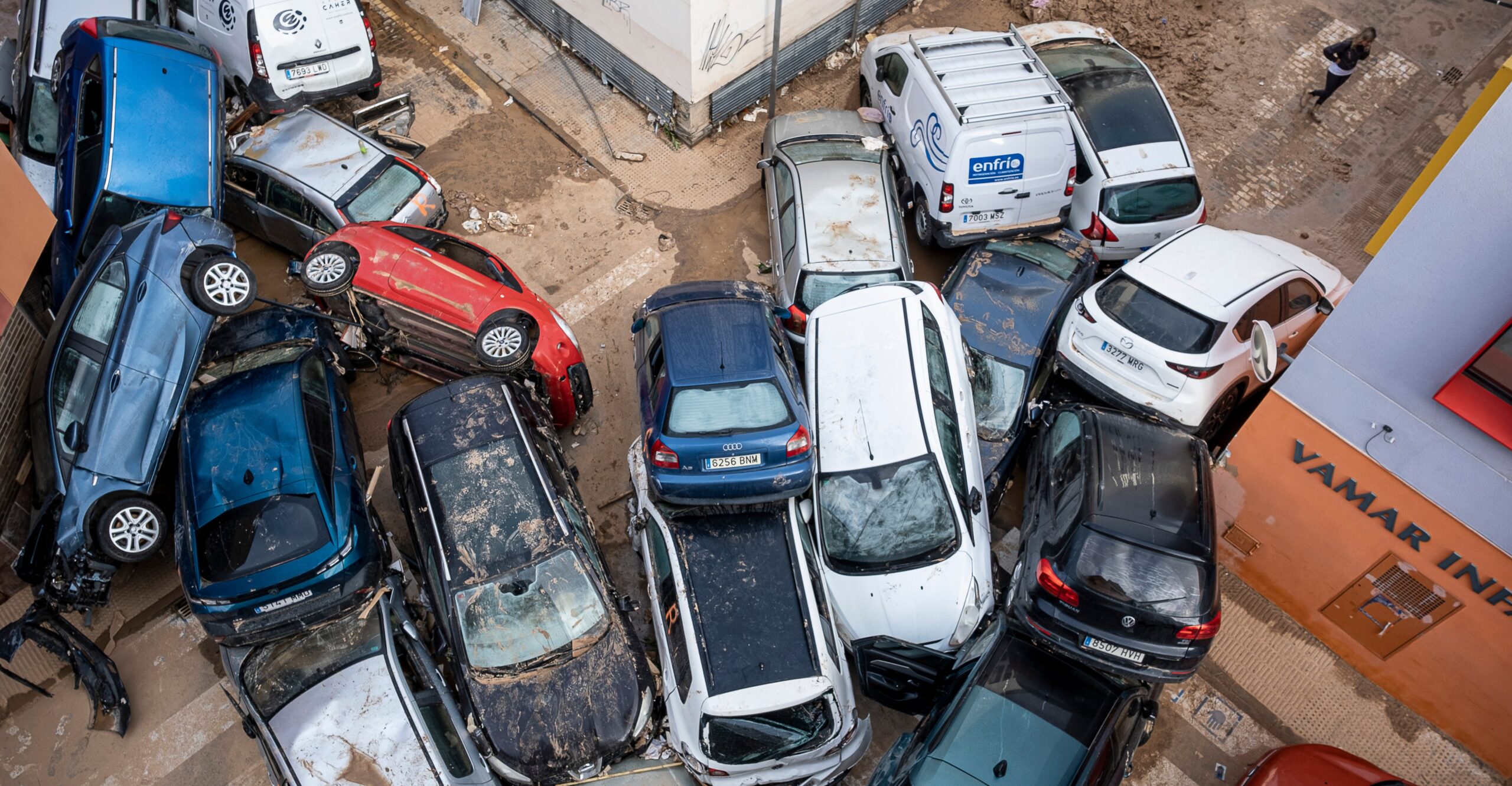 Cars carried by floodwaters, a few on top of another car