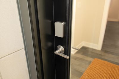 silver door handle with silver pad on a black frame glass door