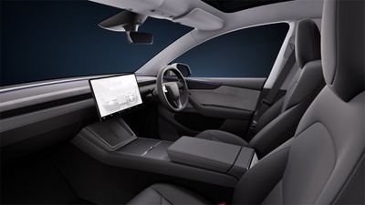 The inside cabin of the Tesla Model Y 2025 refresh, showing a physical turn talk on the steering wheel.