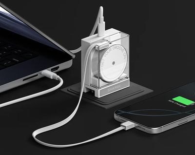 The Sharge Retractable 65 charger plugged into an outlet while connected to a laptop and smartphone.