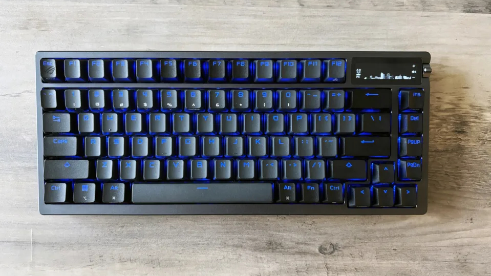 The ASUS ROG Azoth mechanical gaming keyboard on a light brown wooden table.