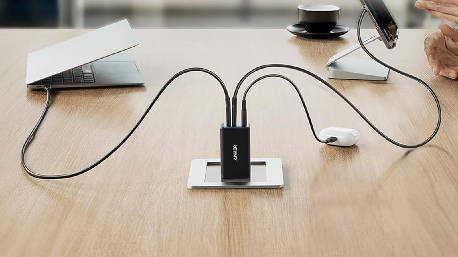 the Anker USB C Charger (Nano 65W) charges three devices at once while plugged into a table