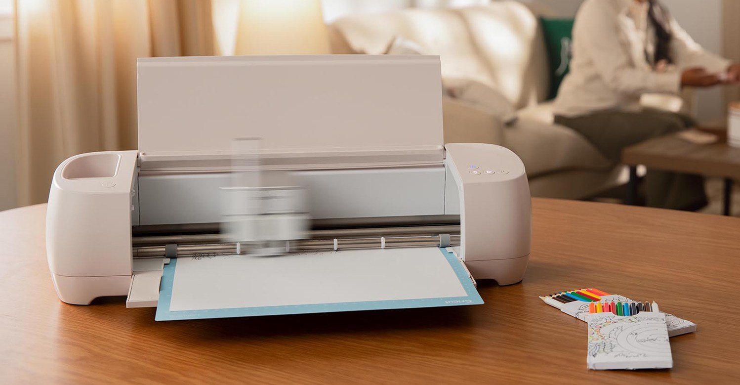 A Cricut crafting machine on a desk using a marker to print an image.