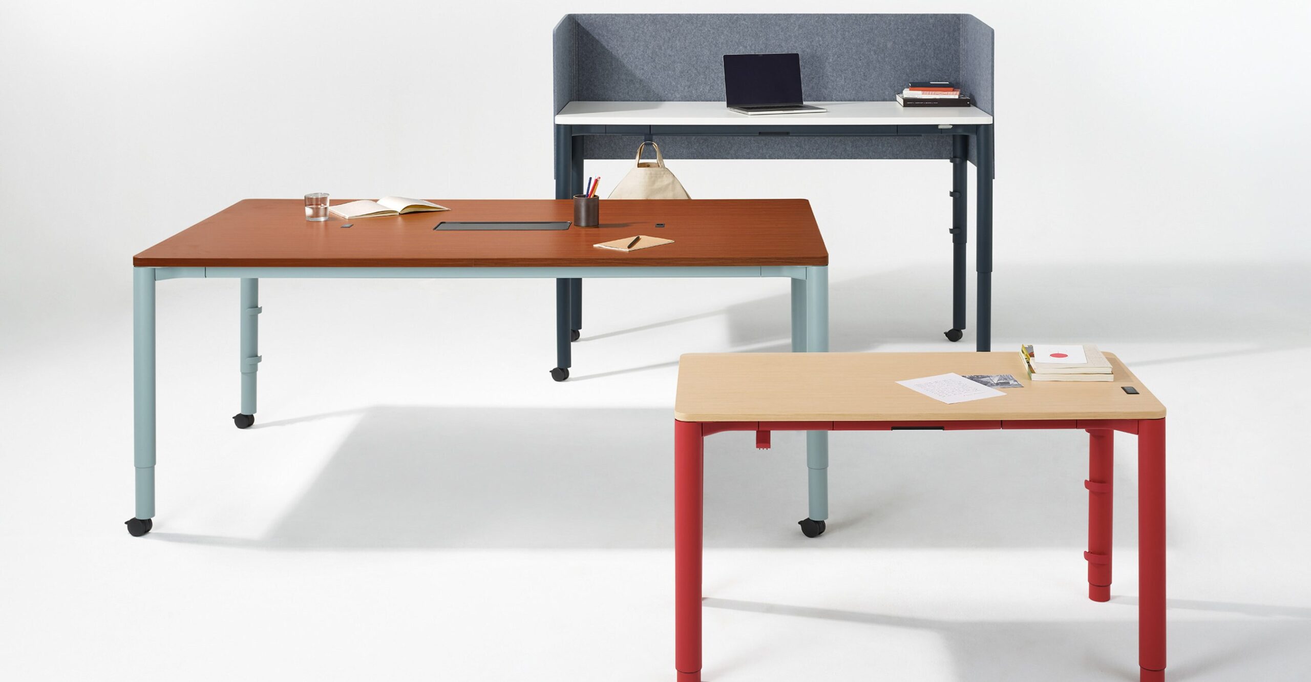 Three versions of Herman Miller’s Spout table with different finishes and accessories.