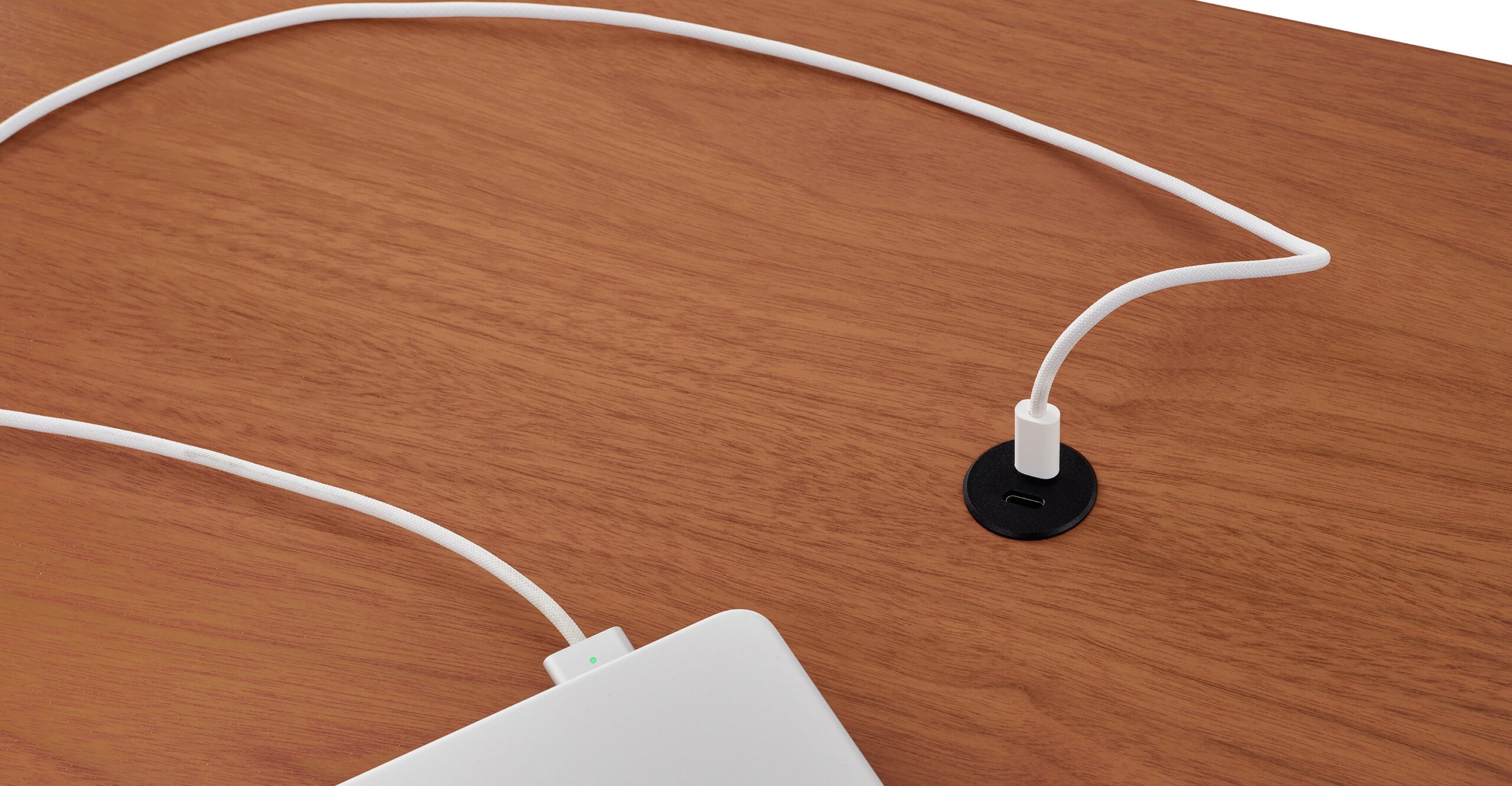 A laptop on top of the Herman Miller Spout desk connected to a USB-C port.