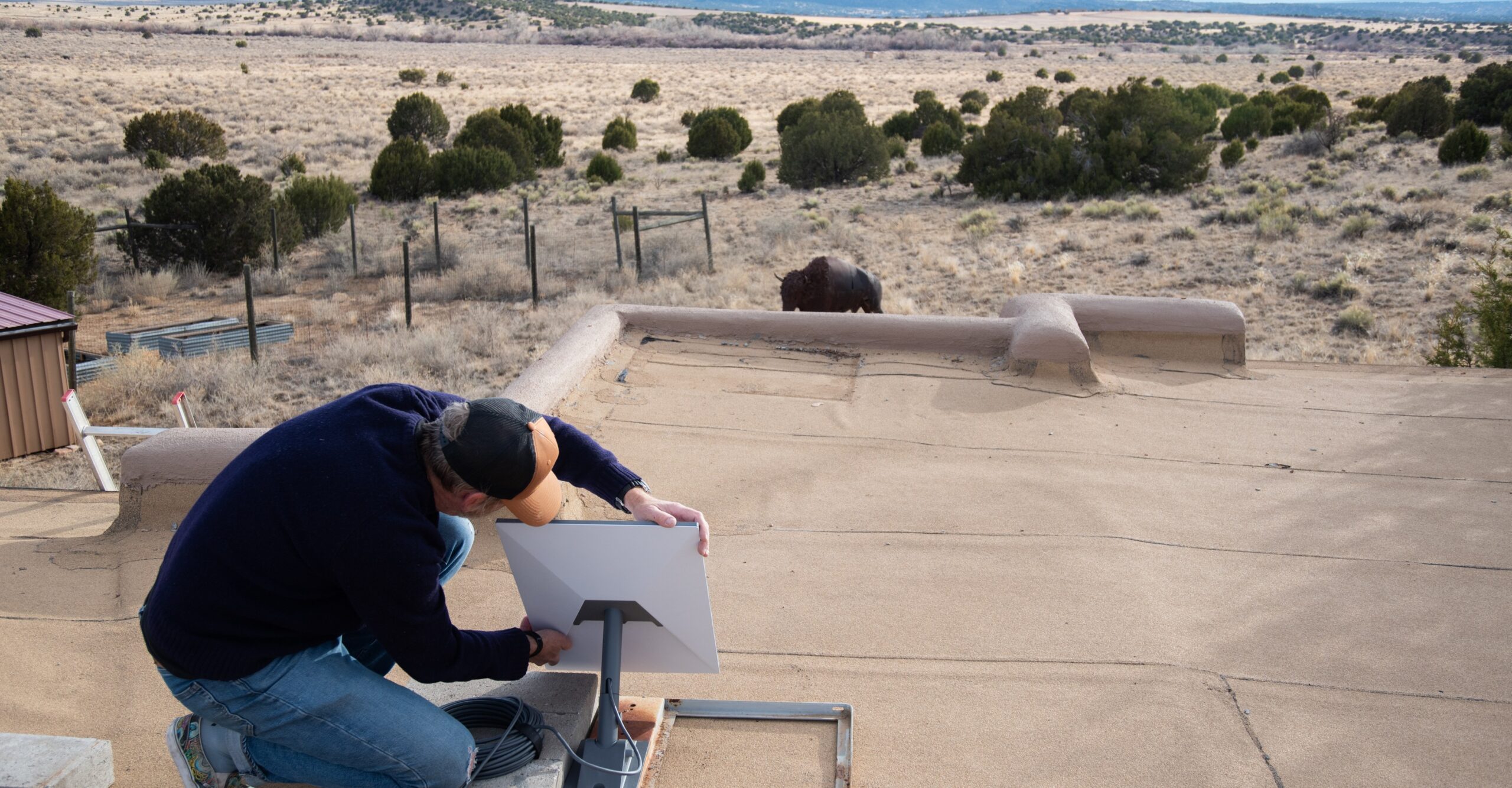 A man sets up a Starlink dish in the desert