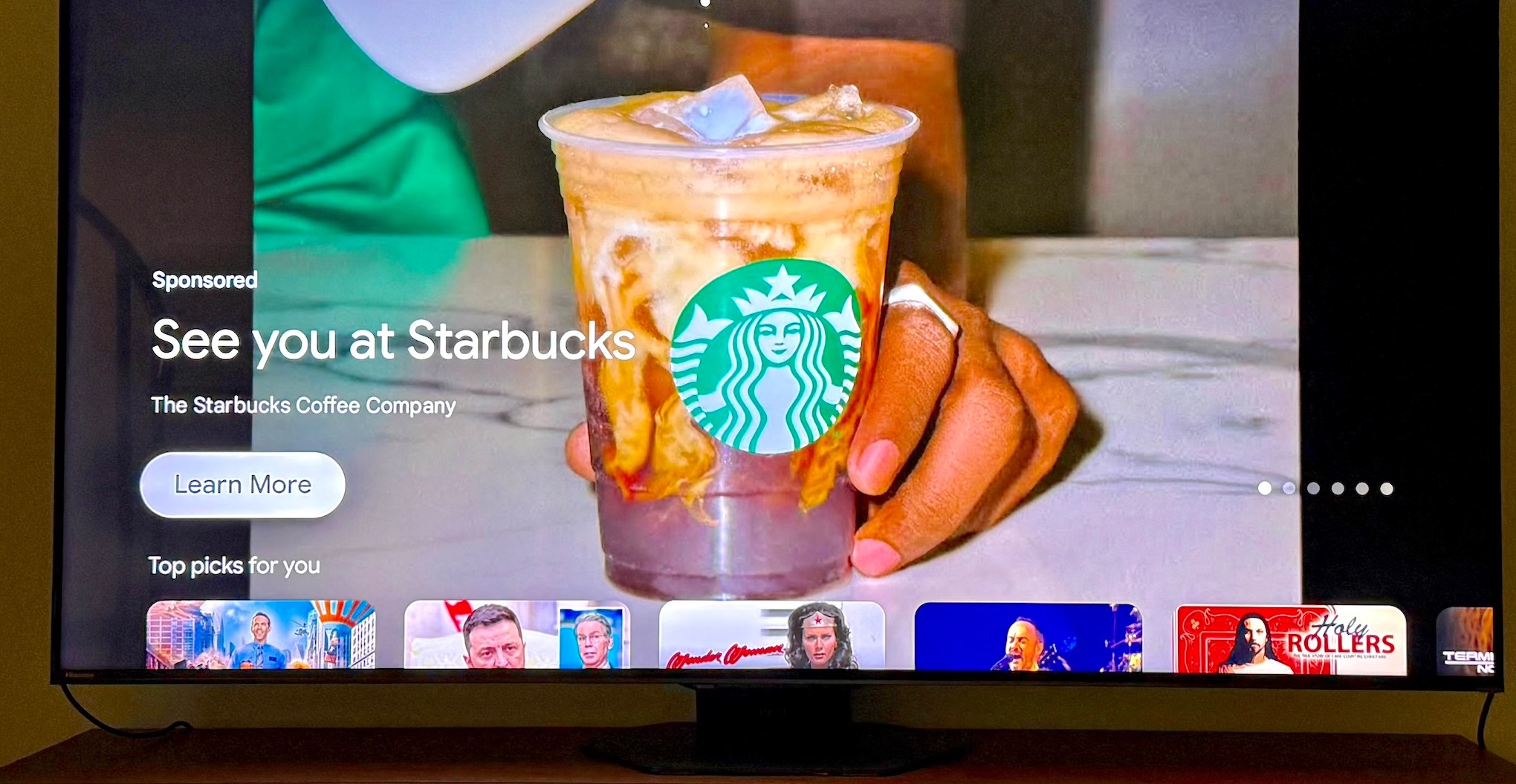 A photo of a full-screen Starbucks ad on a Hisense Google TV.