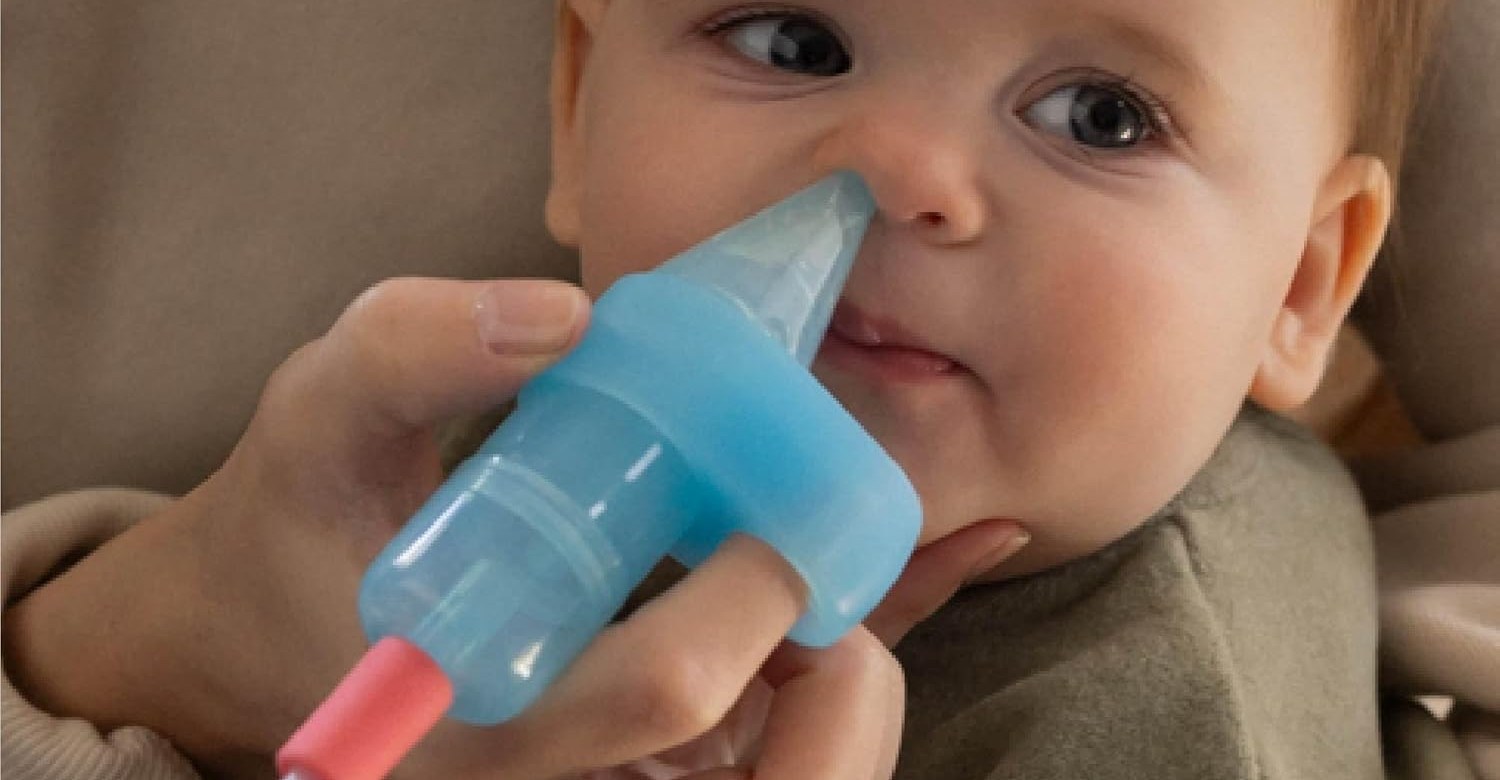 The Electric NoseFrida Pro being used to remove snot from an infant’s nose.