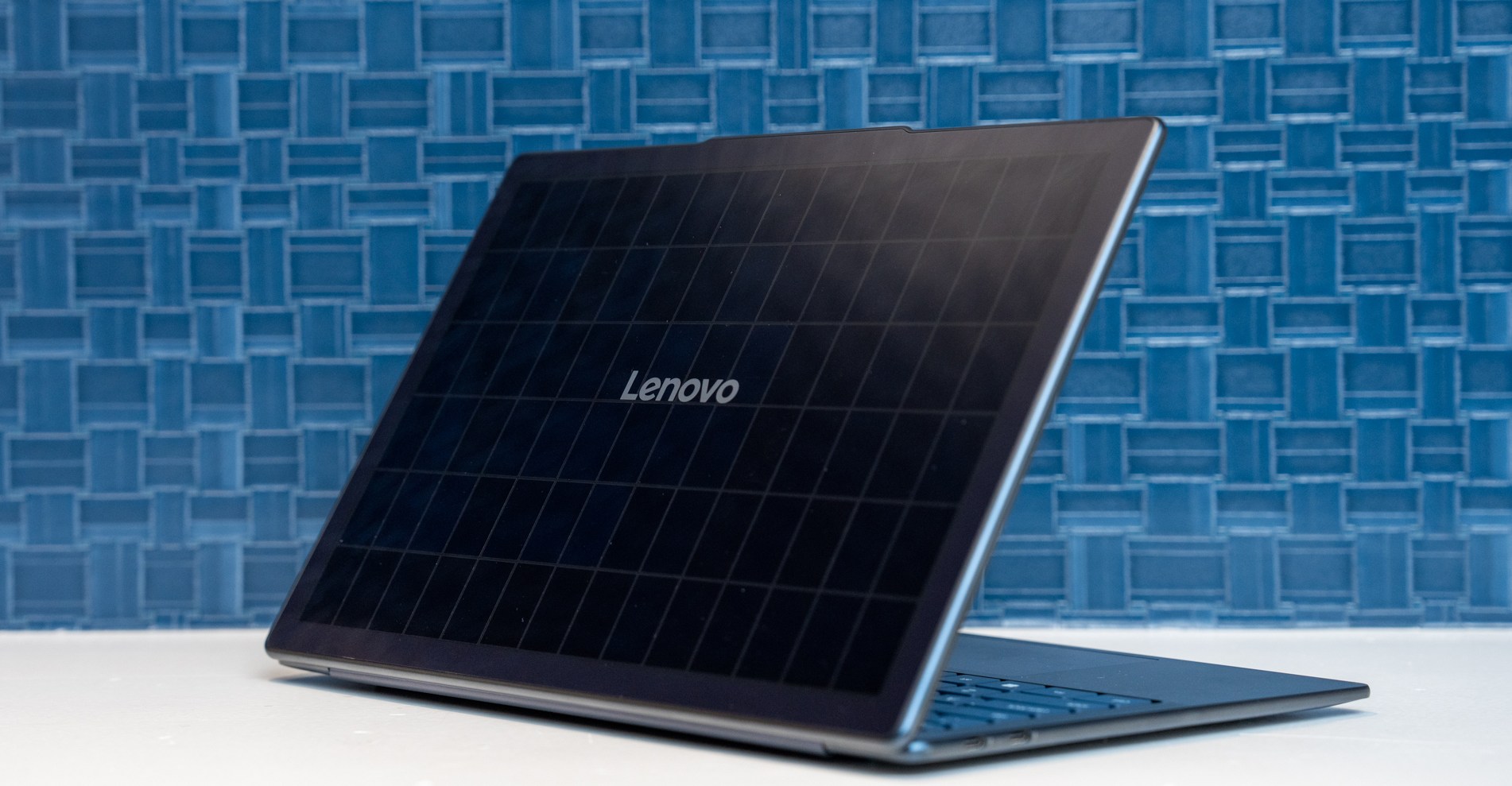 The Lenovo Yoga Solar PC on a white table in front of a blue tile backdrop.