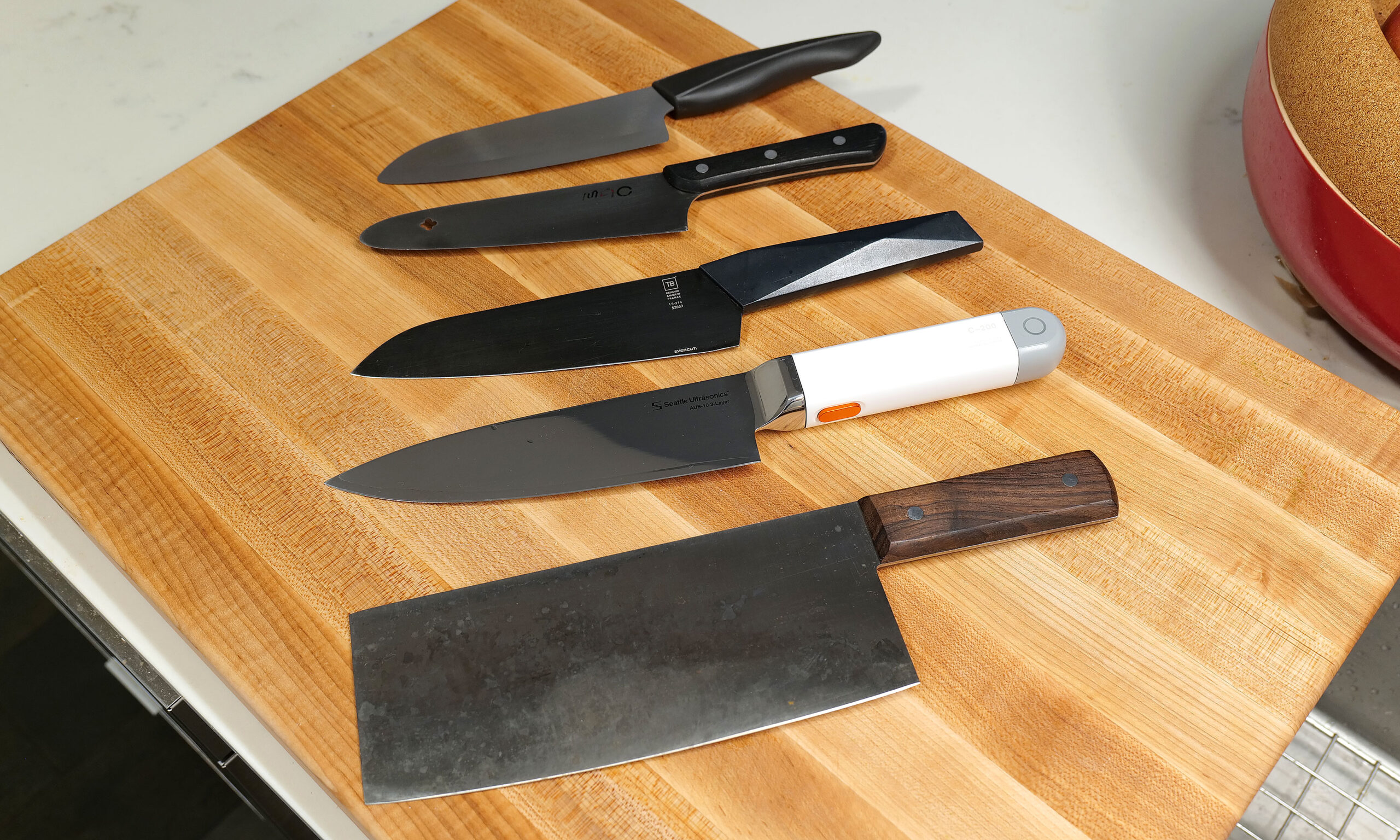 Here's a small selection of knives I own sorted by weight (from top to bottom) compared to the C200: 6-inch Kyocera ceramic knife (97 grams), MAC molybdenum steel chef's knife (110g), Furtif Evercut titanium carbide chef's knife (190g), Seattle Ultrasonics C-200 (328g), Korin carbon steel cleaver (396g).