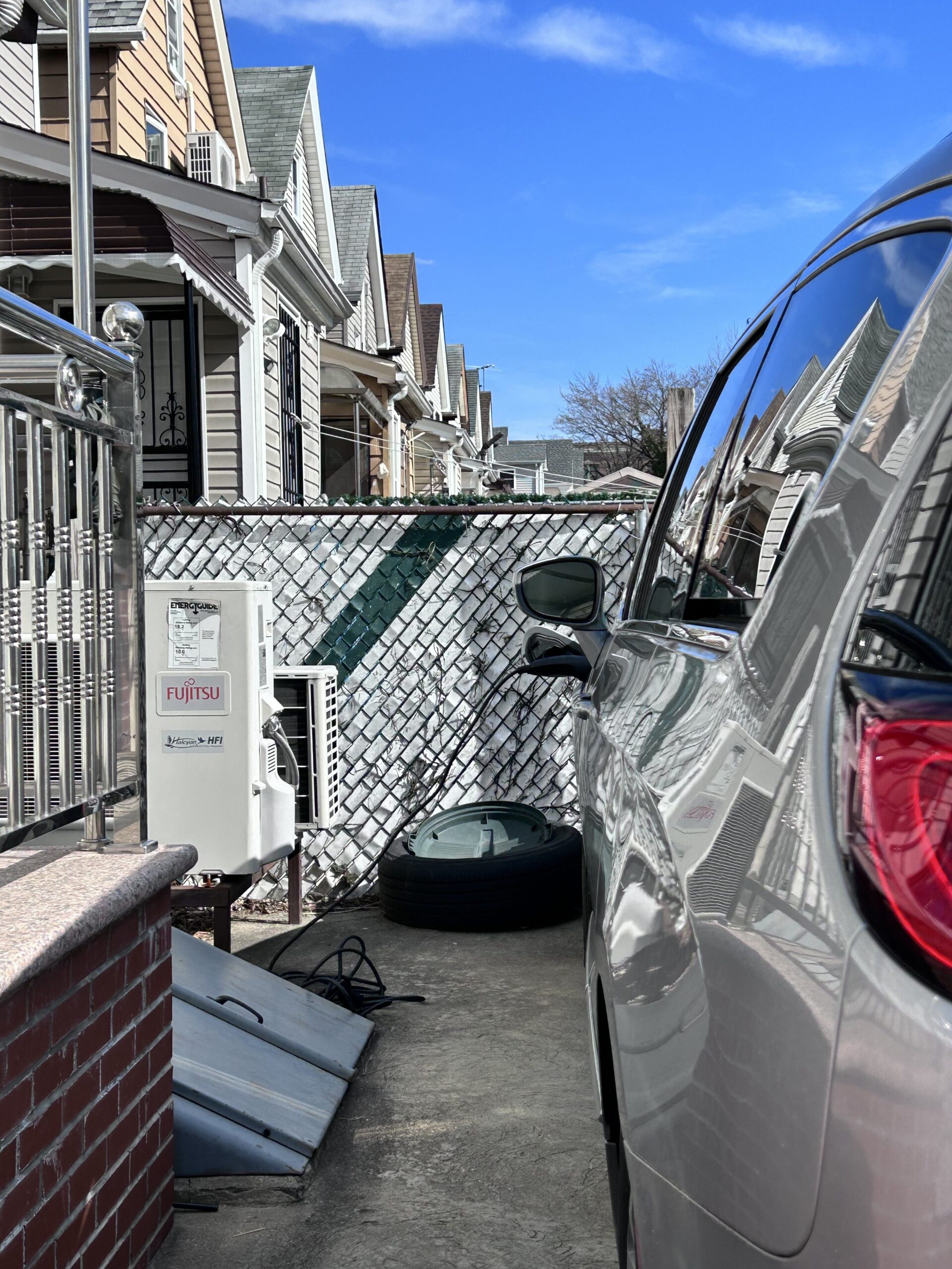 Electric car parked in driveway plugged in and charging with Fujitsu charging station Electric car parked in driveway plugged in and charging with Fujitsu charging station