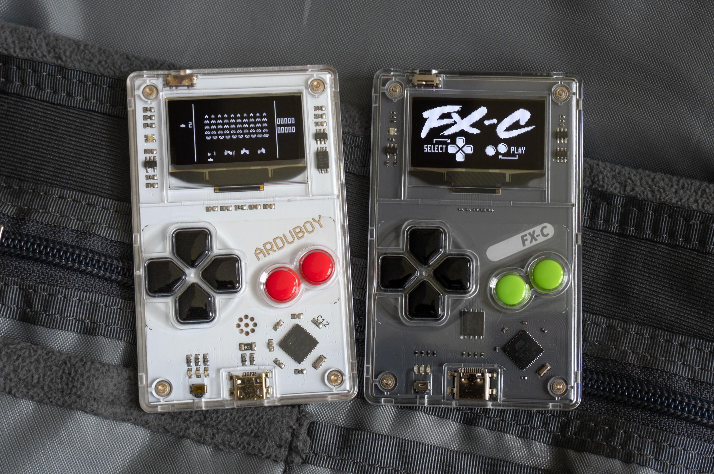 The original Arduboy next to the new Arduboy FX-C sitting on a backpack’s internal pockets.