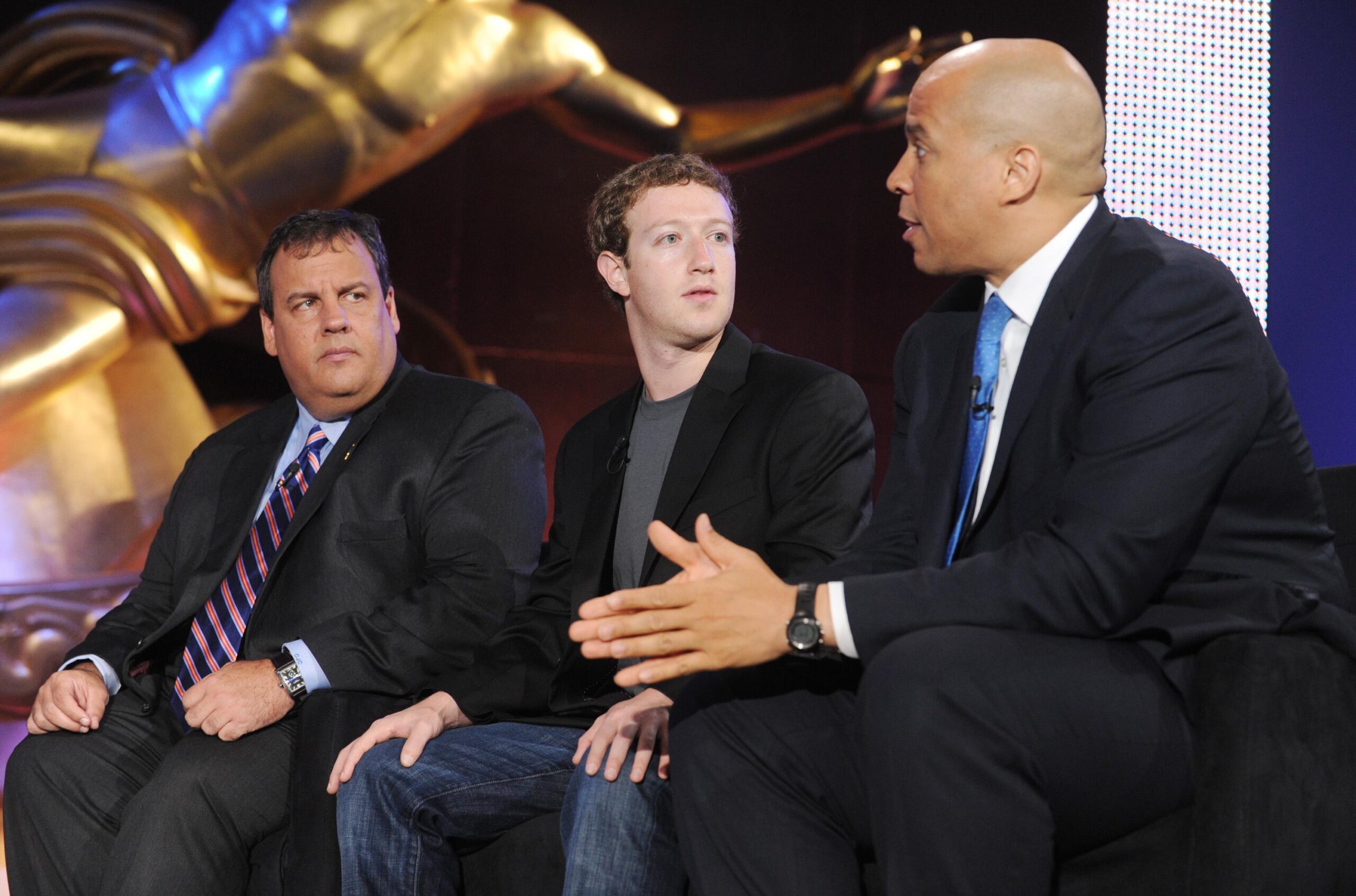Mark Zuckerberg, Chris Christie, and Cory Booker sit and talk in Rockefeller Plaza