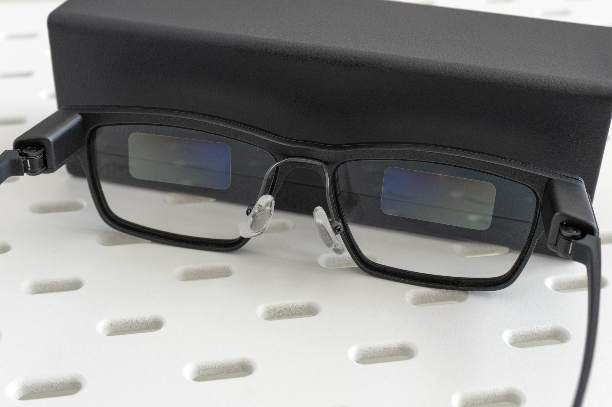 The Xgimi MemoMind One smart glasses leaning against their carrying case.