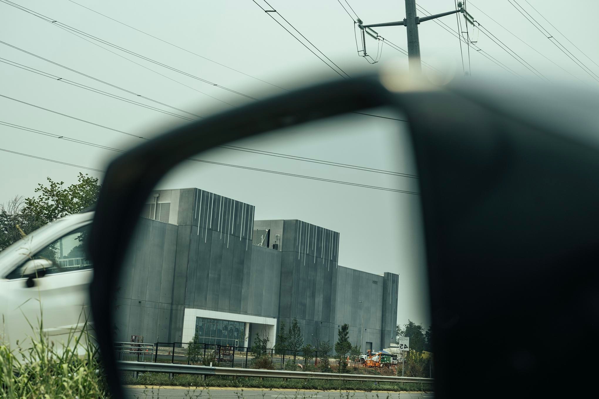 A data center viewed in a side mirror of a car in Ashburn, Virginia.