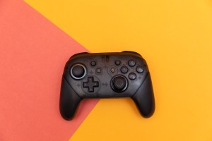 The Nintendo Switch Pro Controller sitting flat on a two-colored backdrop.