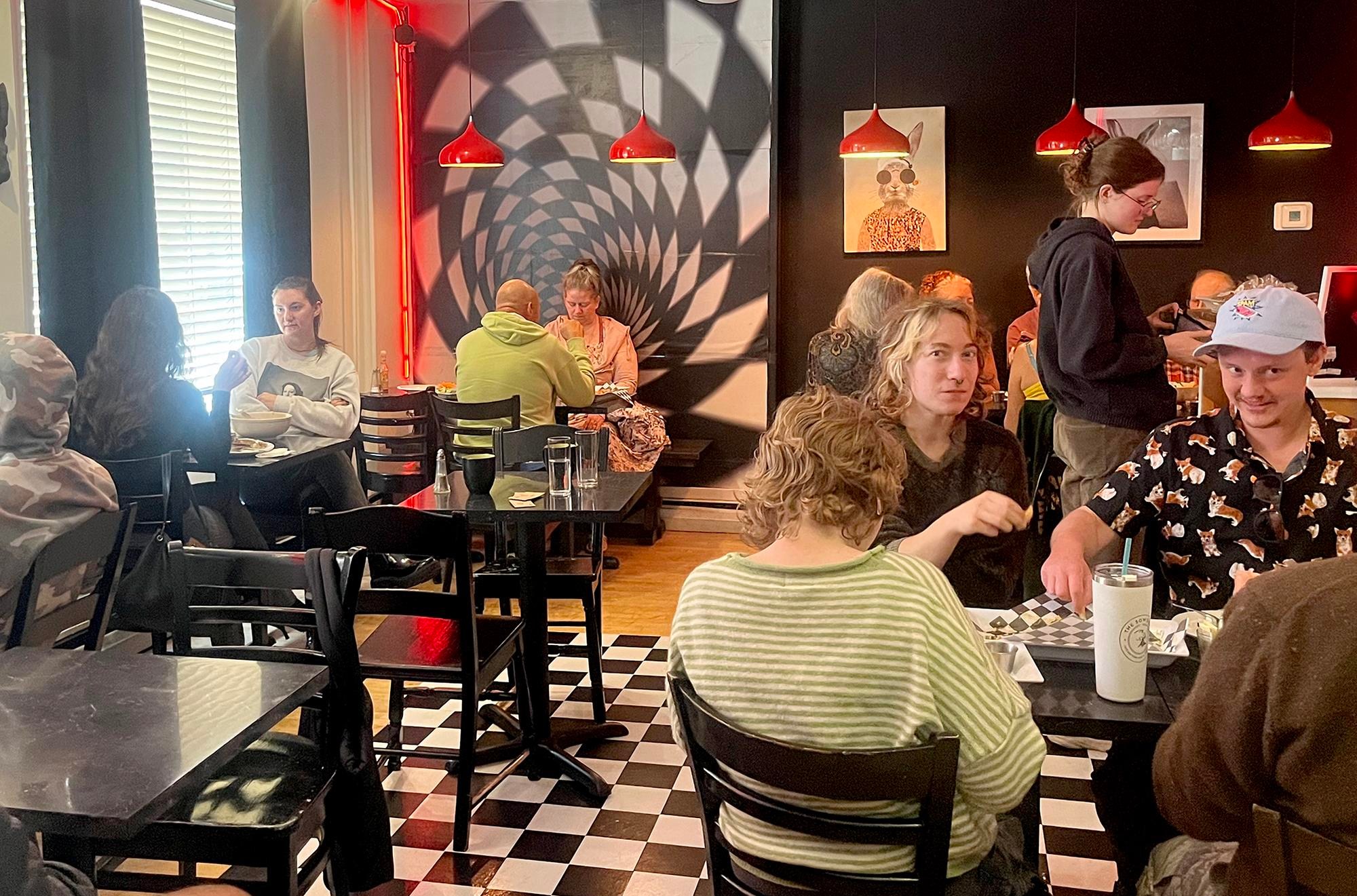 people eating vegan food in a checkered cafe