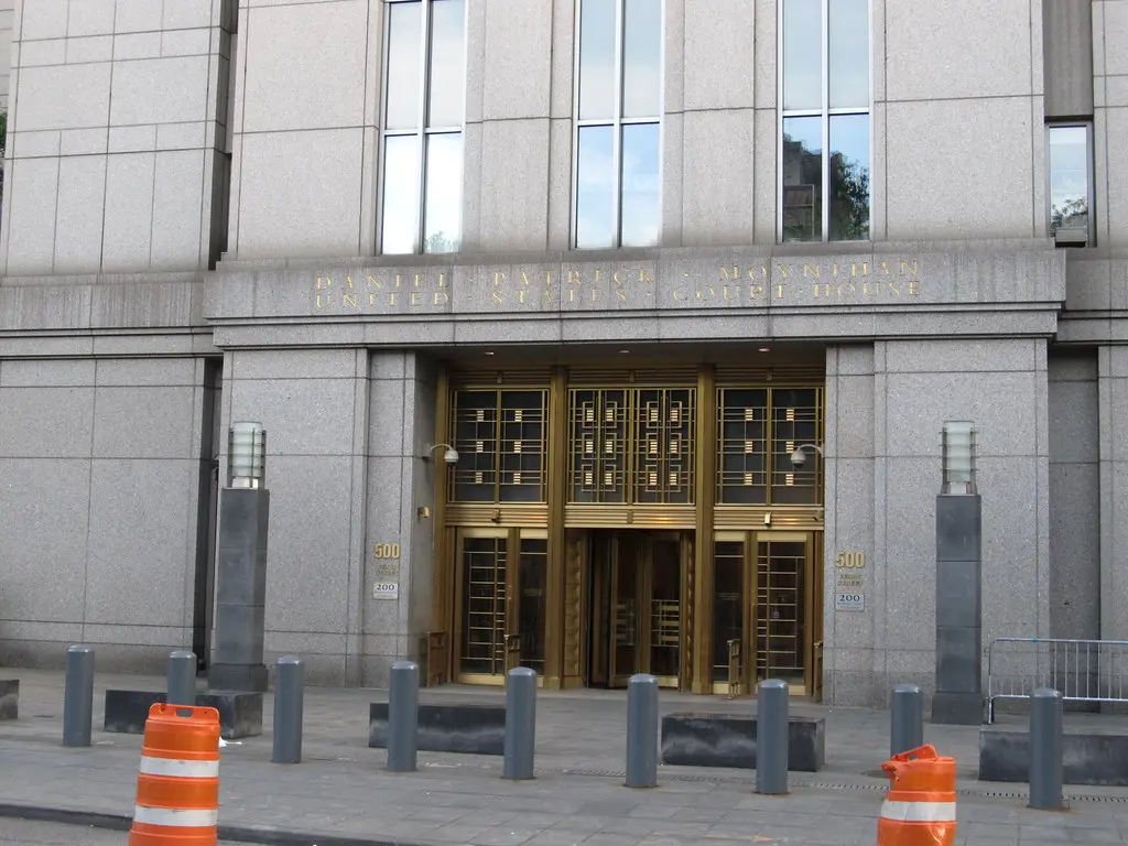 The exterior entrance of the Daniel Patrick Moynihan United States Courthouse with gold-trimmed doors.