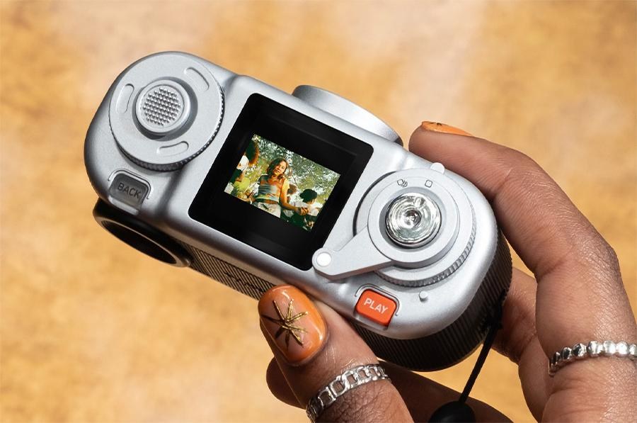 A close-up of the controls and LCD screen on top of the Fujifilm Instax Pal 2 camera.