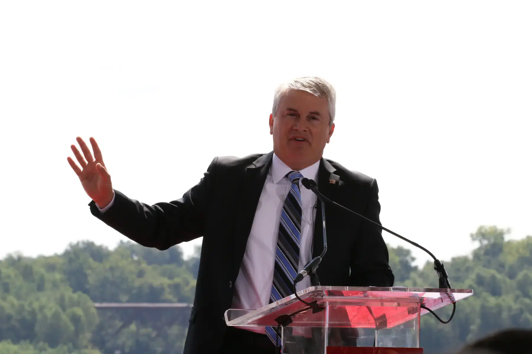 Representative James Comer speaking at a podium outdoors.